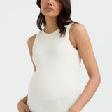 A pregnant woman wearing a white sleeveless ribbed tank top.
