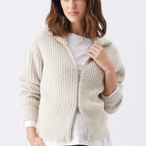 Chunky Zip Knit Maternity Cardigan (Oat) | Ripe Maternity Woman wearing a beige ribbed knit cardigan over a white shirt on a light gray background