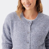 A woman wearing a light gray heathered knit cardigan with a button-up front, shown from the chest up against a plain light background.