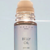 Belly oil bottle with roller ball on a light blue background